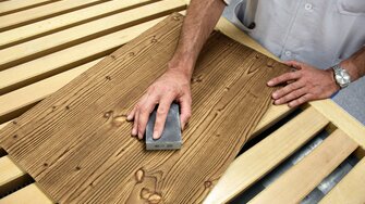 Po nanesení prvej vrstvy laku drevo opatrne prebrúsime.